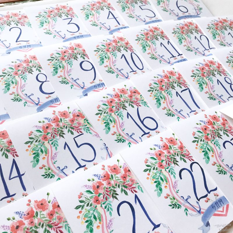 Hand painted nautical wedding crest table cards with hand drawn numbers by artist Michelle Mospens. // Mospens Studio